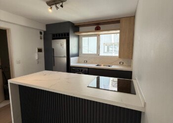 Isla central de cocina integrada con cubierta de mármol y carpintería a medida