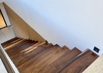 Escalera con viga central metálica y escalones de madera en voladizo para vivienda contemporánea