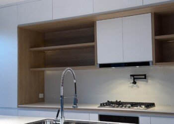 Frente de cocina con columnas de piso a techo y horno empotrado en carpintería a medida