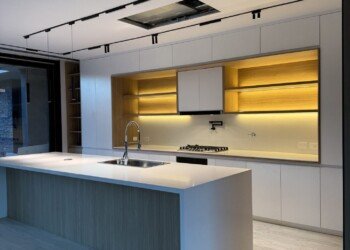Mobiliario de cocina integral con isla central y nicho con iluminación LED cálida para obra residencia
