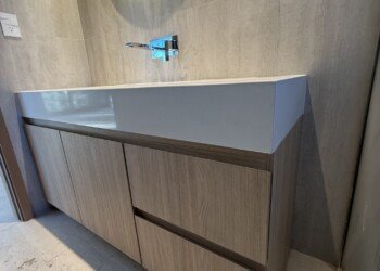 Mueble de baño a medida con cajoneras, puertas batientes y grifería embutida a la pared