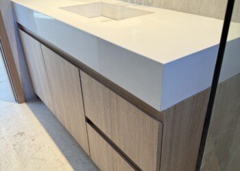 Vanitory moderno a medida con bacha integrada y terminación en madera para proyecto de interiorismo