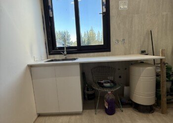 Mobiliario de lavadero a medida con bajomesada blanco y espacio previsto para lavarropas para obra residencial