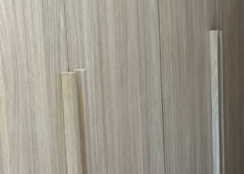 Placard empotrado para pasillo con tiradores verticales integrados a medida en carpintería integral.